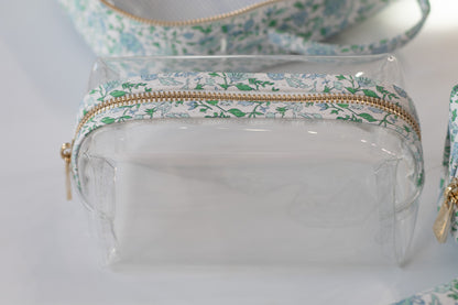 Clear pouch with floral patterned zipper on a light background