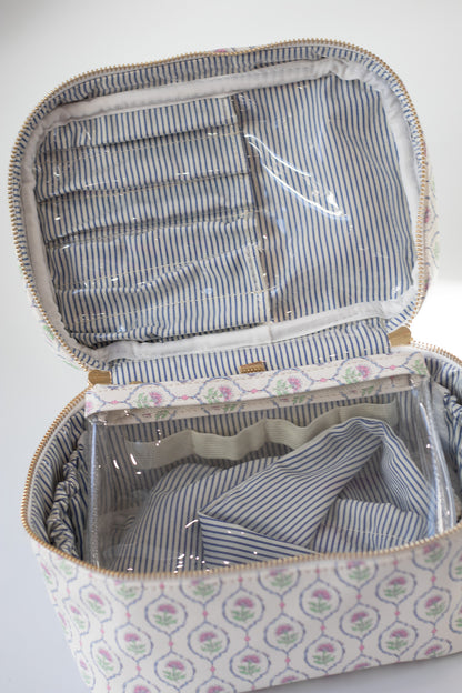 Open fabric suitcase with striped interior and floral exterior on a white background