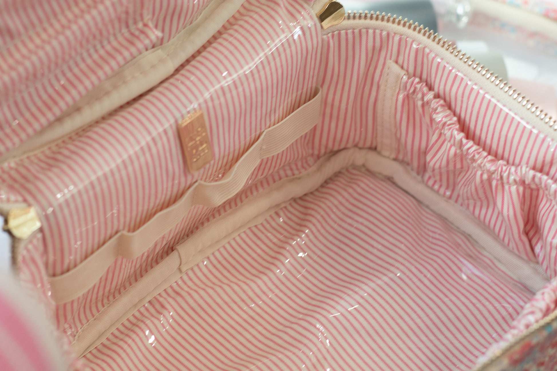 Close-up of a pink striped bag with a gold zipper