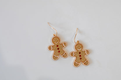 Gingerbread man-shaped earrings on a light gray background