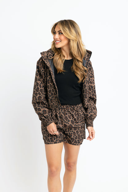 Woman wearing a leopard print hoodie and shorts set on a white background