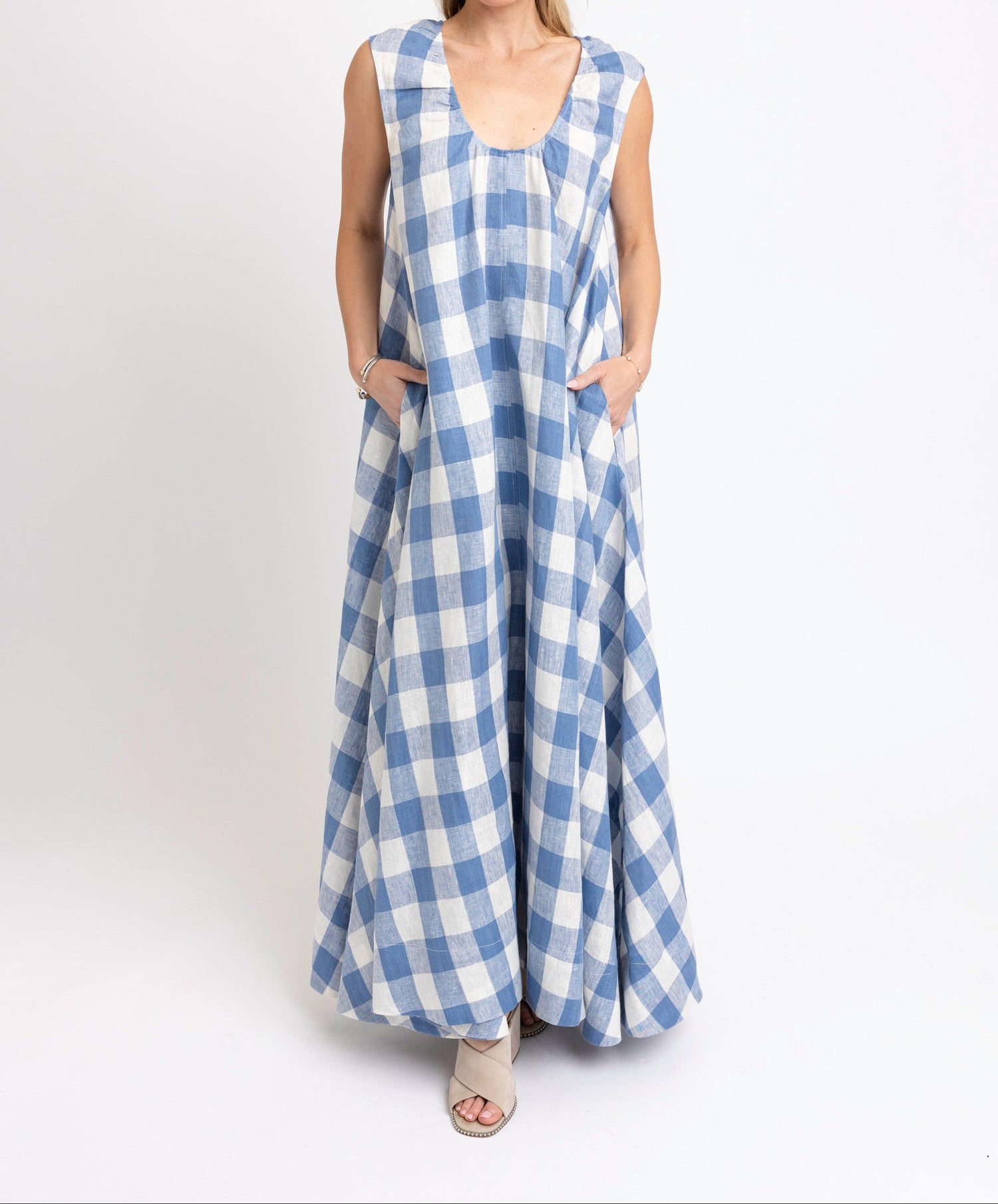 Woman wearing a blue and white checkered dress on a white background