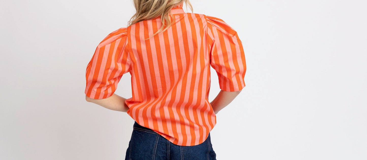 Person wearing a red and white striped shirt and blue shorts on a white background