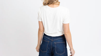 Person wearing blue denim shorts and a white t-shirt on a white background