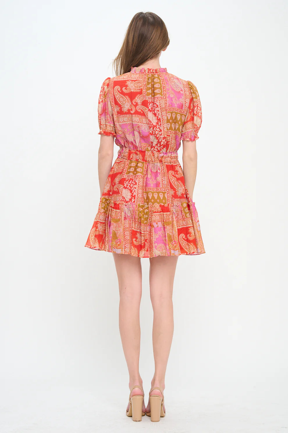 Woman wearing a colorful patterned dress on a white background