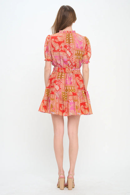 Woman wearing a colorful patterned dress on a white background