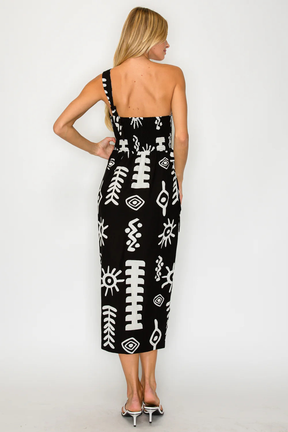 Woman wearing a black dress with white patterns on a white background