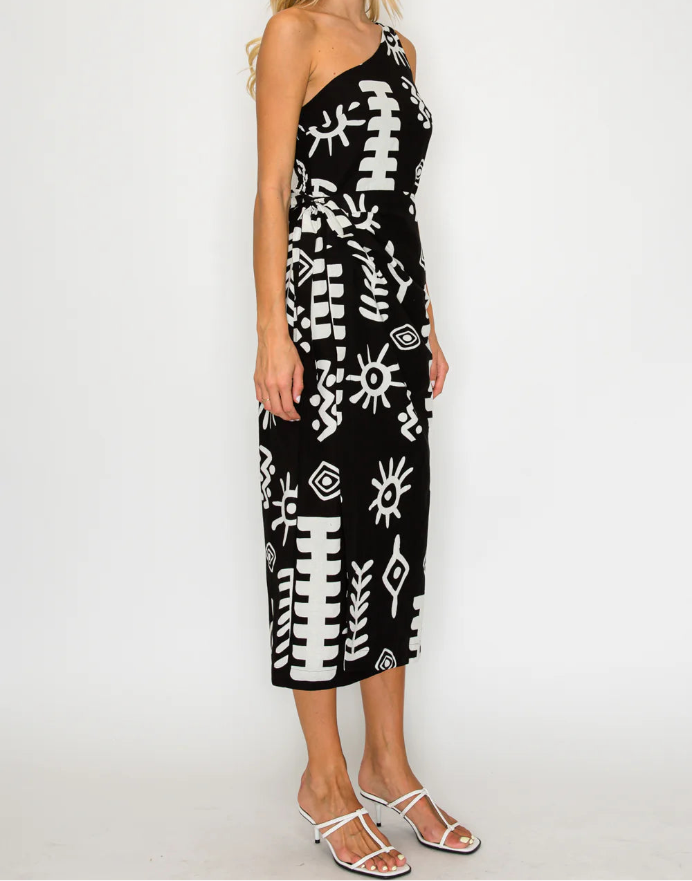 Woman wearing a black dress with white patterns on a white background