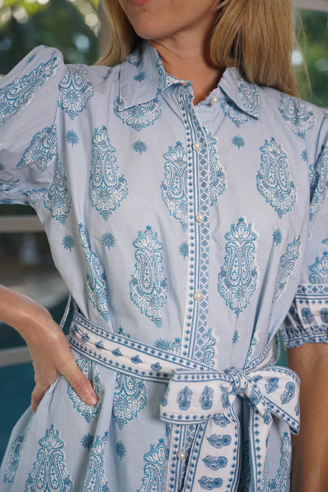 Woman wearing a blue and white patterned dress with a blurred background