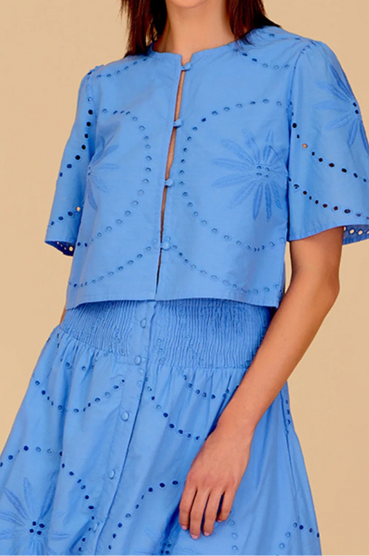 Woman wearing a blue outfit with a beige background