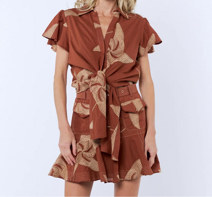 Woman wearing a brown dress with floral patterns on a white background