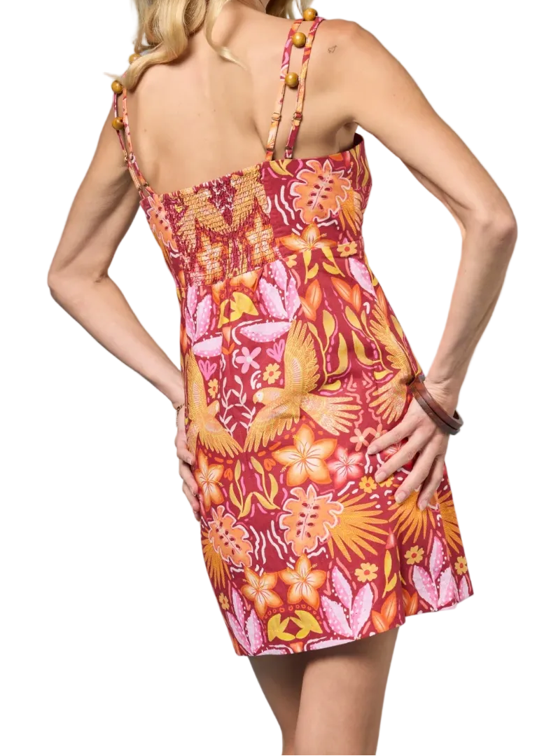 Woman wearing a colorful floral dress against a white background.