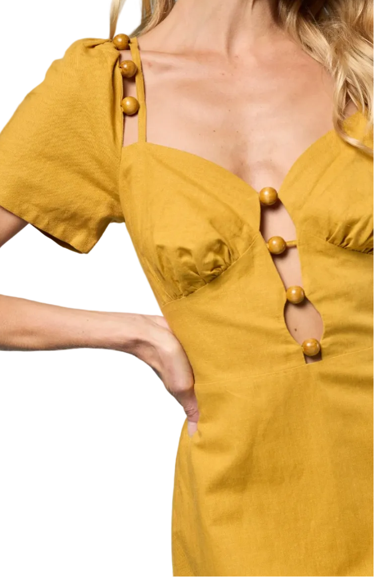 Yellow dress with button details on a plain background