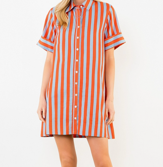 Person wearing an orange and blue striped shirt dress on a plain background