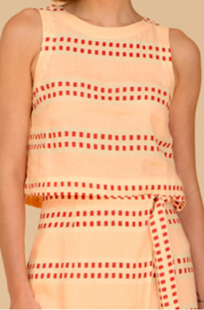 Woman wearing a beige dress with red pattern on a beige background