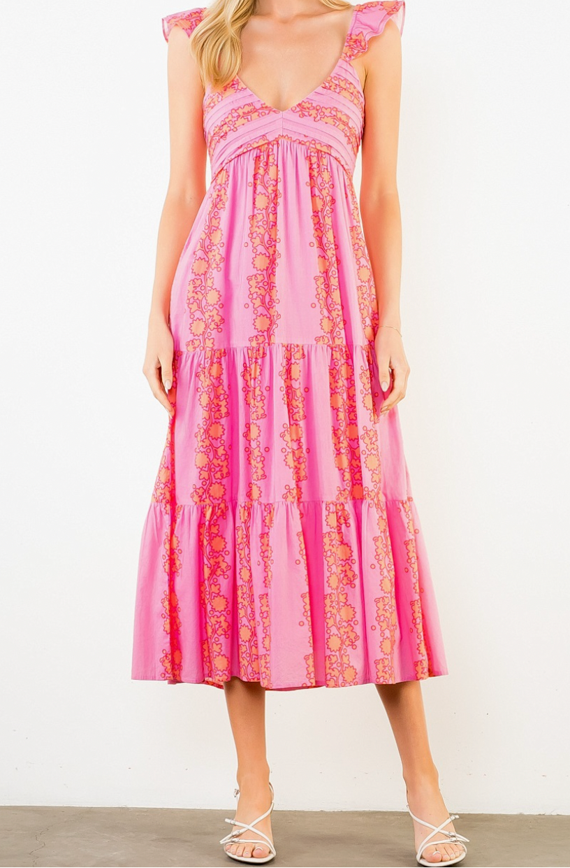 Woman wearing a pink and red patterned dress on a white background