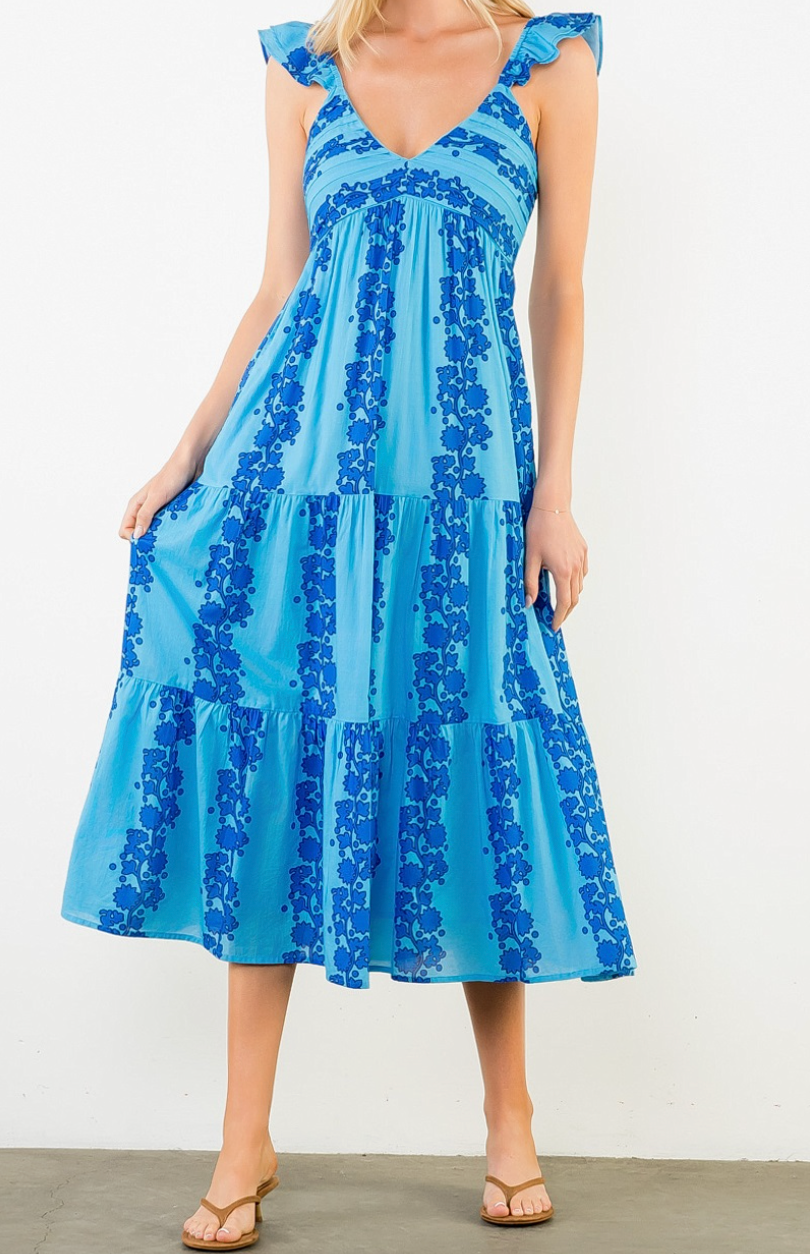 Woman wearing a blue dress with floral pattern on a white background