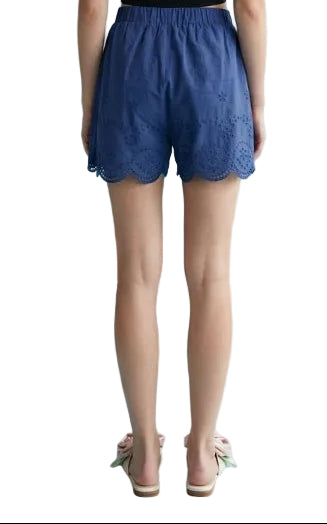 Person wearing blue lace shorts on a light blue background