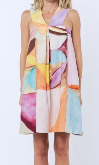 Colorful abstract patterned dress on a plain background