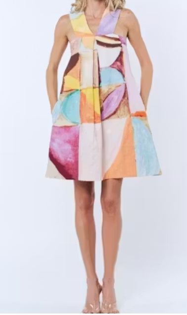 Woman wearing a colorful geometric-patterned dress on a white background