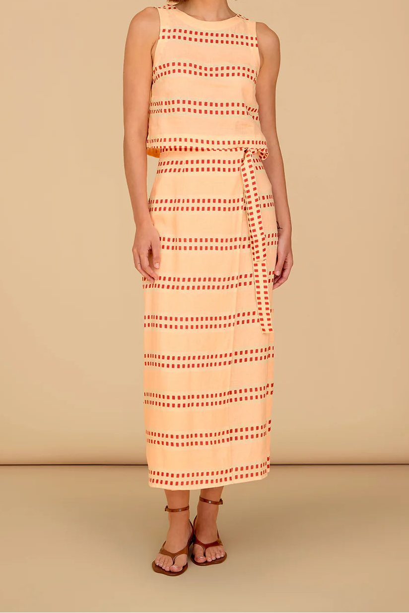 Woman wearing a sleeveless dress with a geometric pattern on a beige background