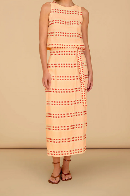 Woman wearing a sleeveless dress with a geometric pattern on a beige background