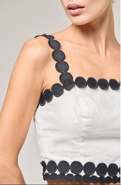 White dress with black circular patterns on a plain background