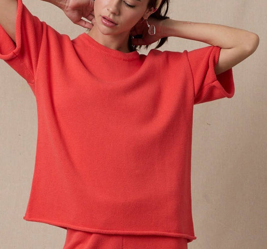 Woman wearing a red outfit with a beige background