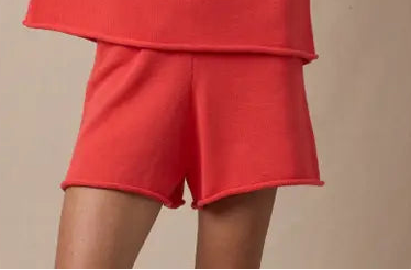 Person wearing a red sweater against a beige background