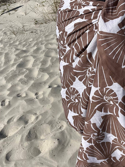Brown and white floral patterned fabric on a sandy background