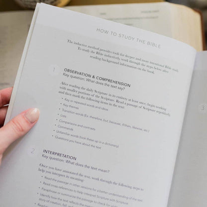 Open book with text on studying the Bible held by a hand