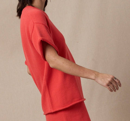 Woman wearing a red outfit against a beige background