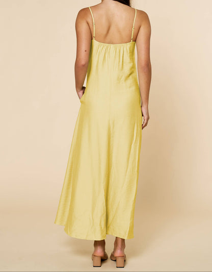Woman wearing a yellow dress against a beige background