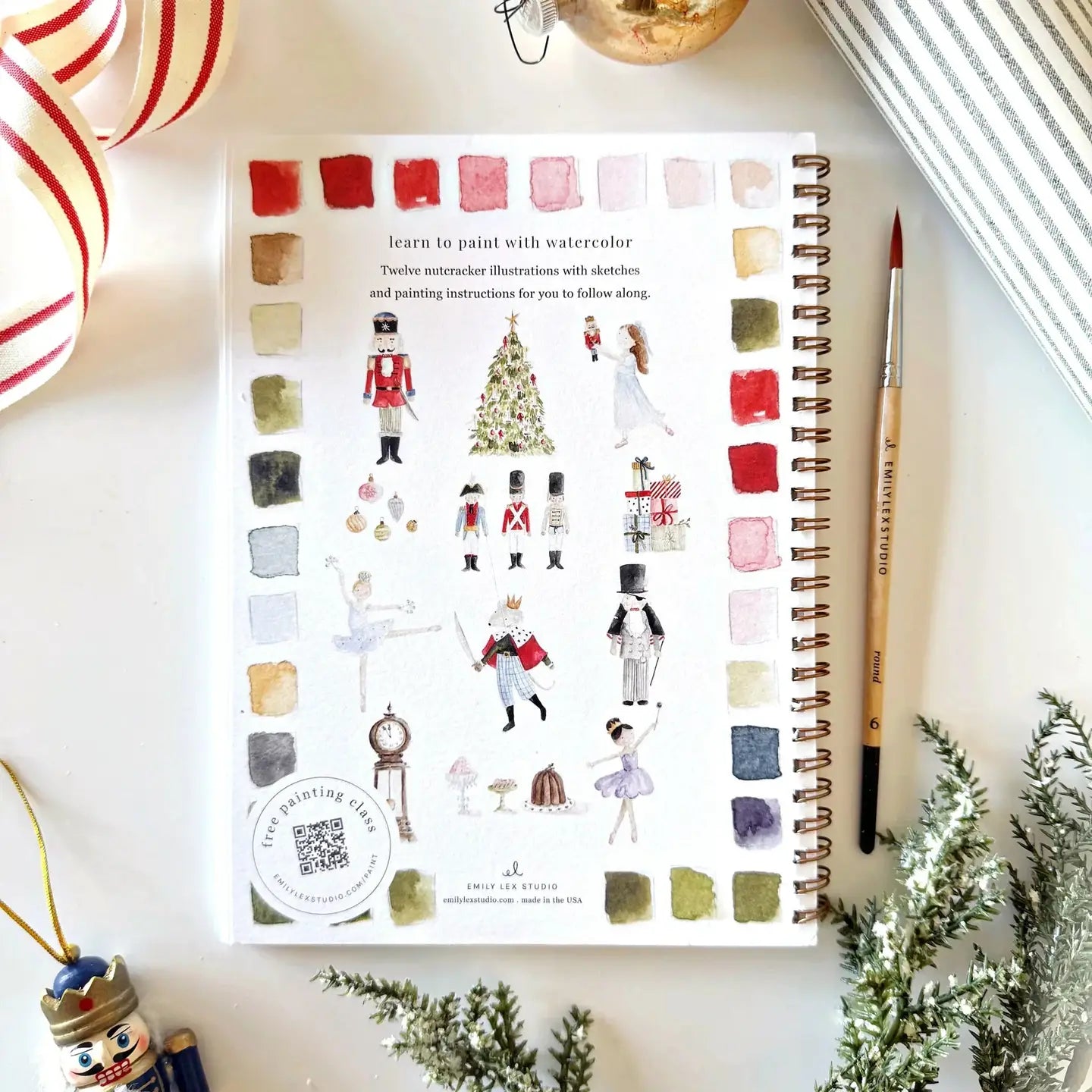 Wendy Goo's art book with watercolor illustrations on a decorative surface with Christmas decorations.