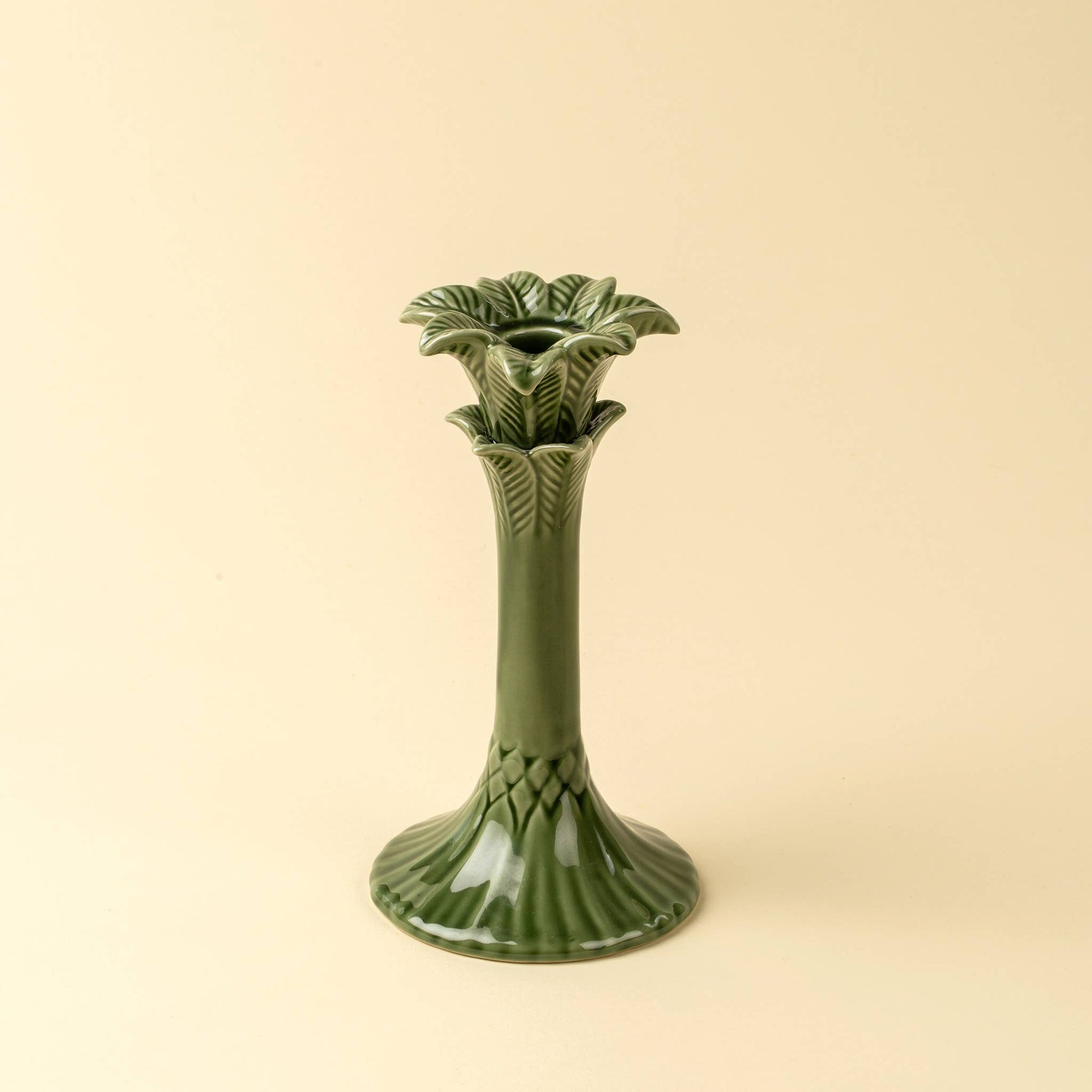 Green ceramic candle holder on a beige background