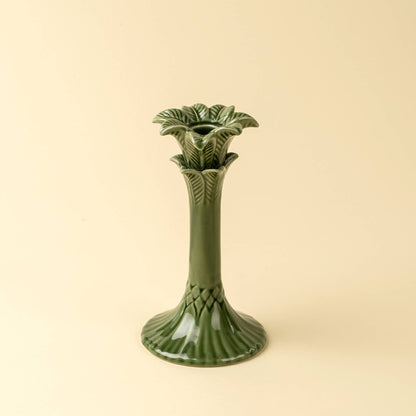 Green ceramic candle holder on a beige background
