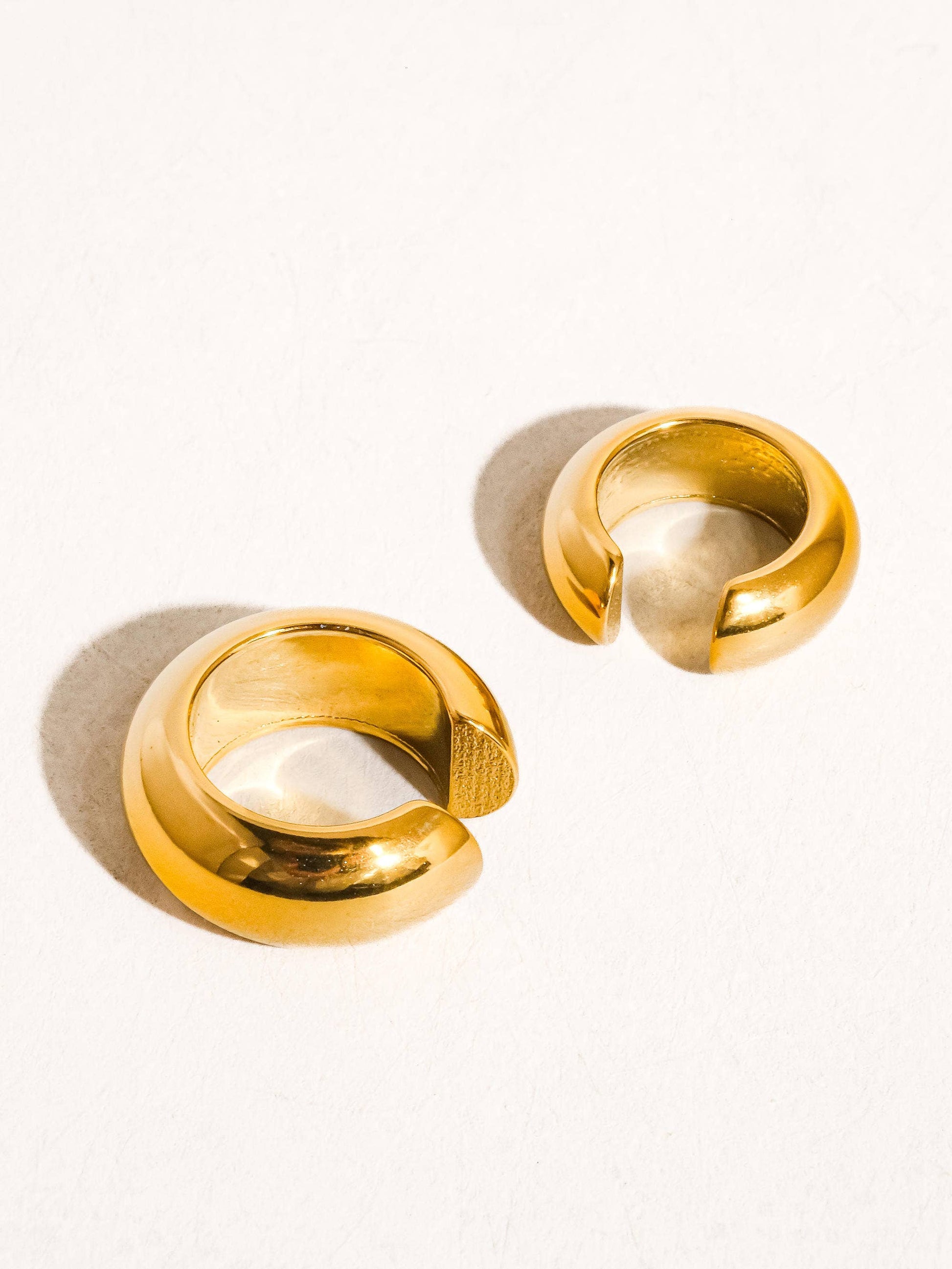 Pair of gold cuff earrings on a white background