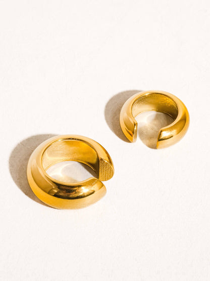 Pair of gold cuff earrings on a white background