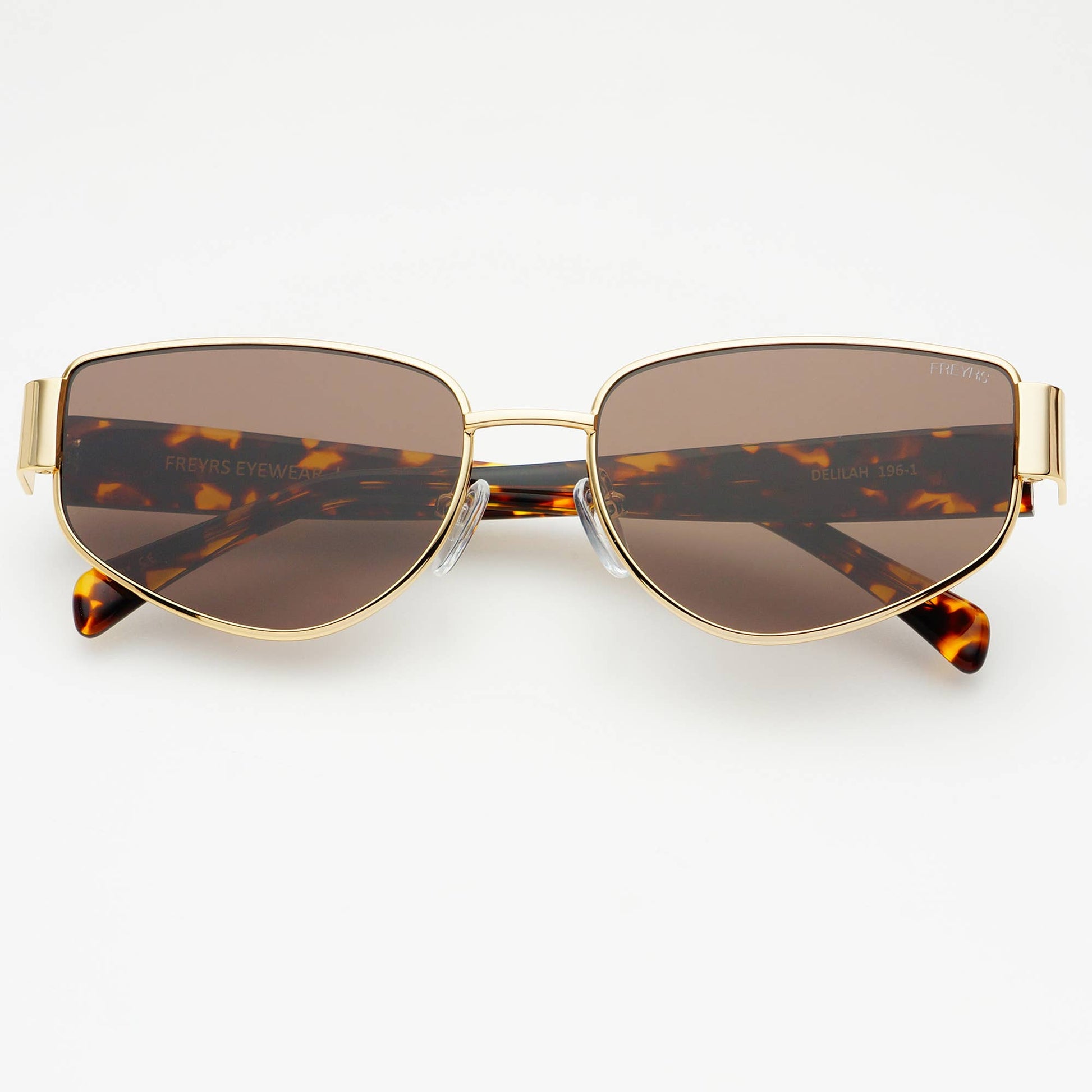 Sunglasses with gold frame and tortoiseshell accents on a white background