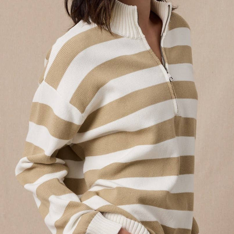 Woman wearing a beige and white striped sweater with a beige headband against a beige background