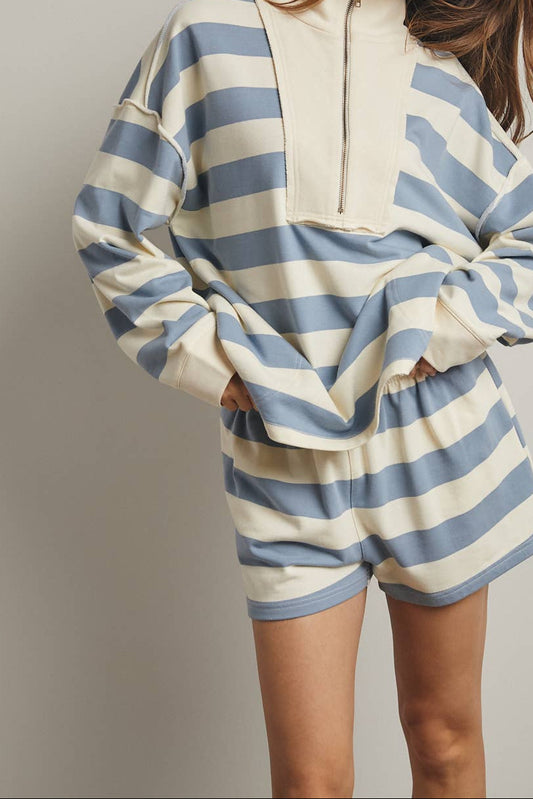 Person wearing a blue and white striped outfit against a plain background