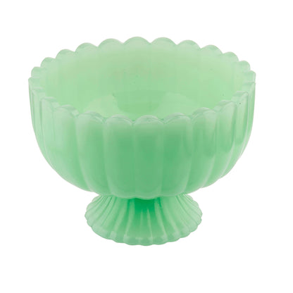 Green glass bowl with ribbed design on a white background