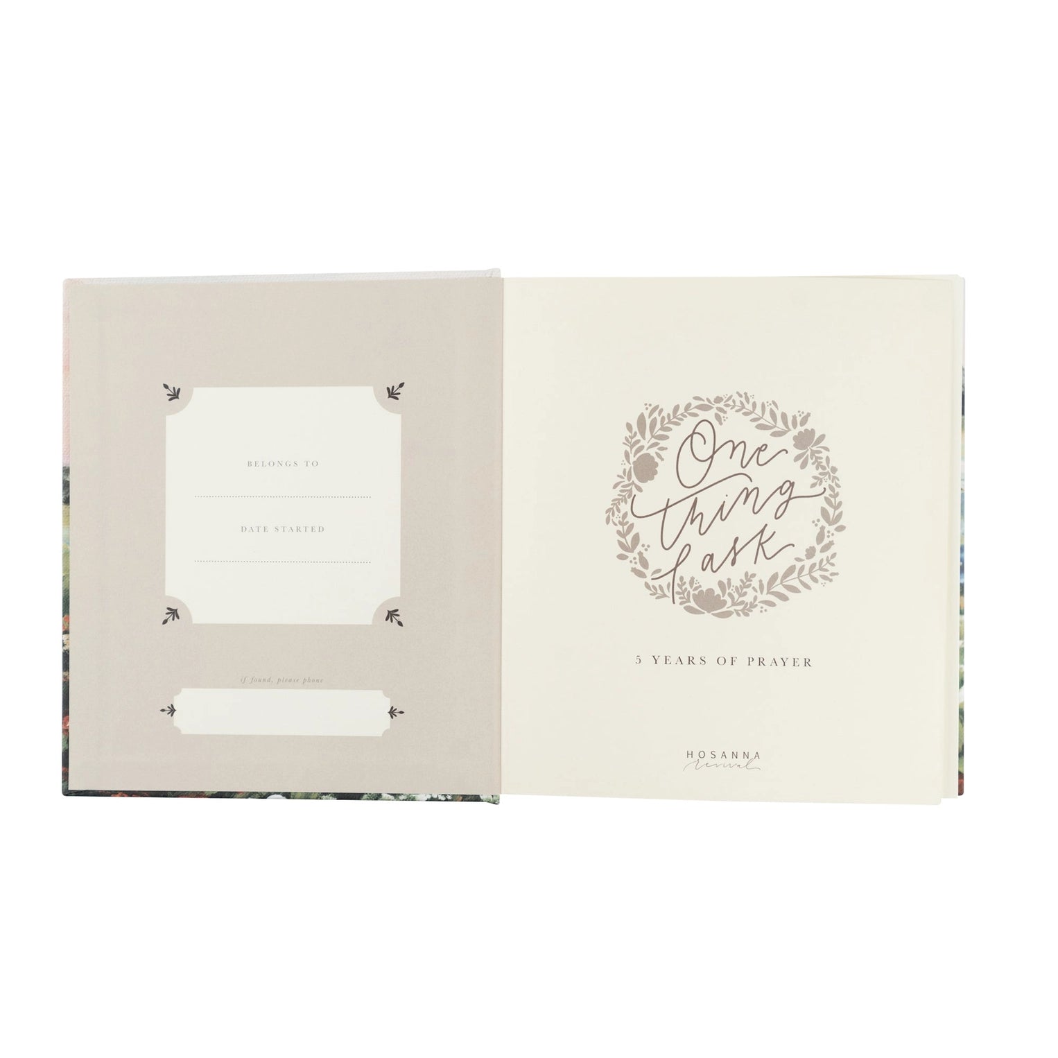 An open book or journal shown against a white background, with the left page in a light warm gray-beige tone and the right page in cream featuring a floral wreath and the words 'One thing at a time' and '3 Years of Prayer.'.