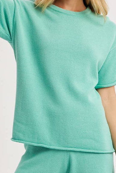 Woman wearing a mint green outfit on a white background