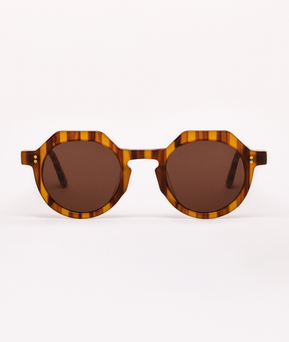 Sunglasses with tortoiseshell frame and brown lenses on a white background