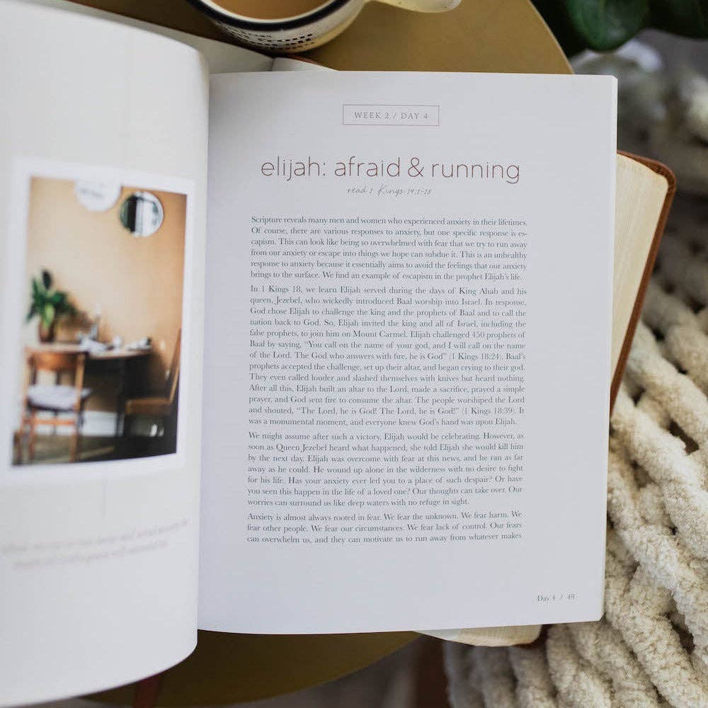 Open book with text and a photo of a room, placed on a surface with a blurred background.