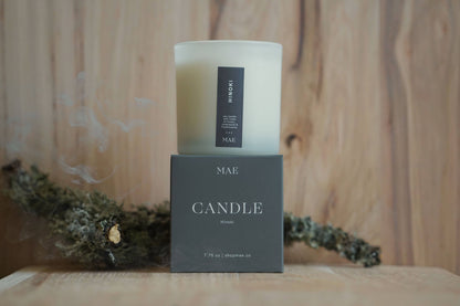 Candle with packaging on a wooden surface