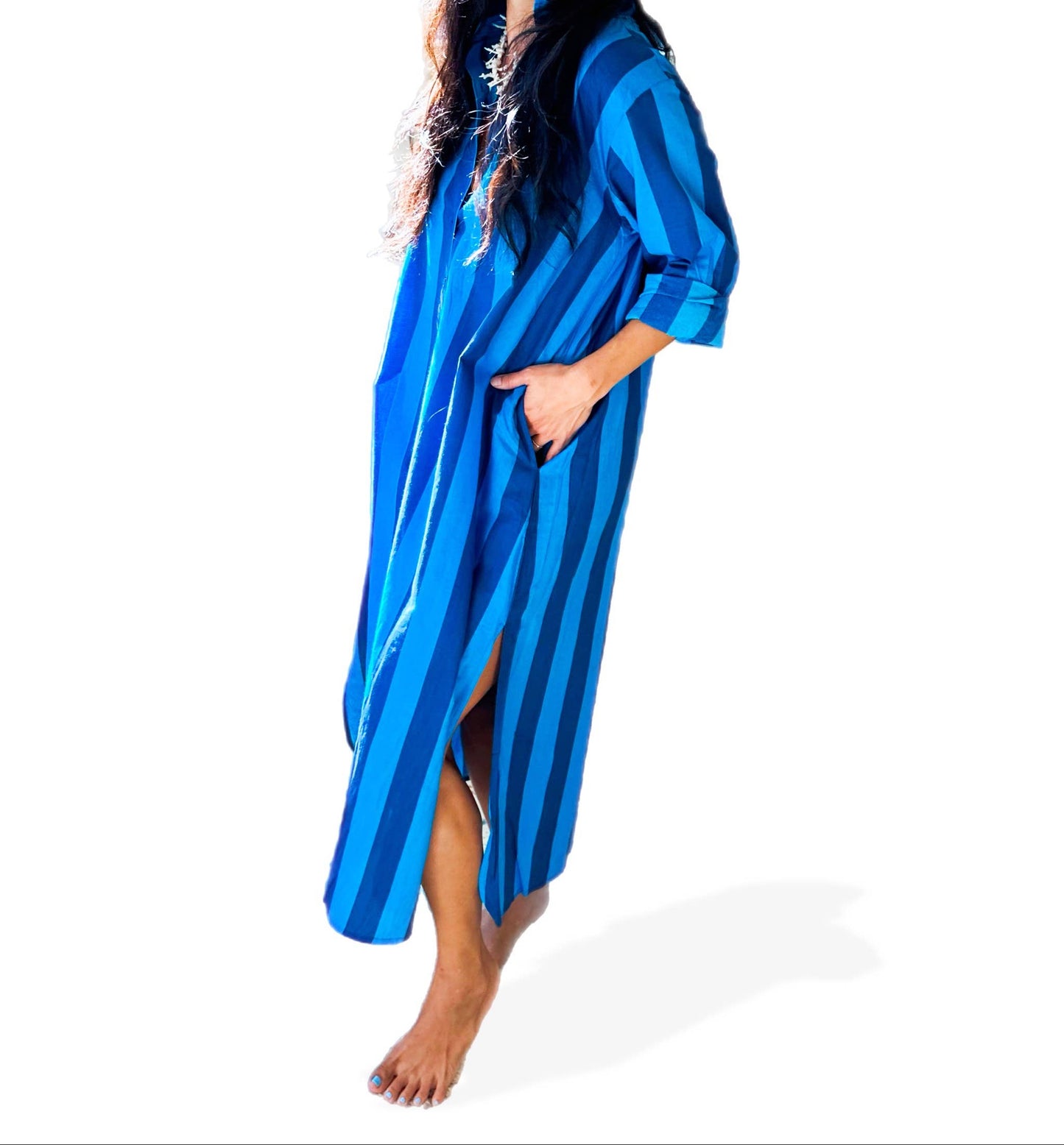 Woman wearing a blue striped poncho and cap on a white background