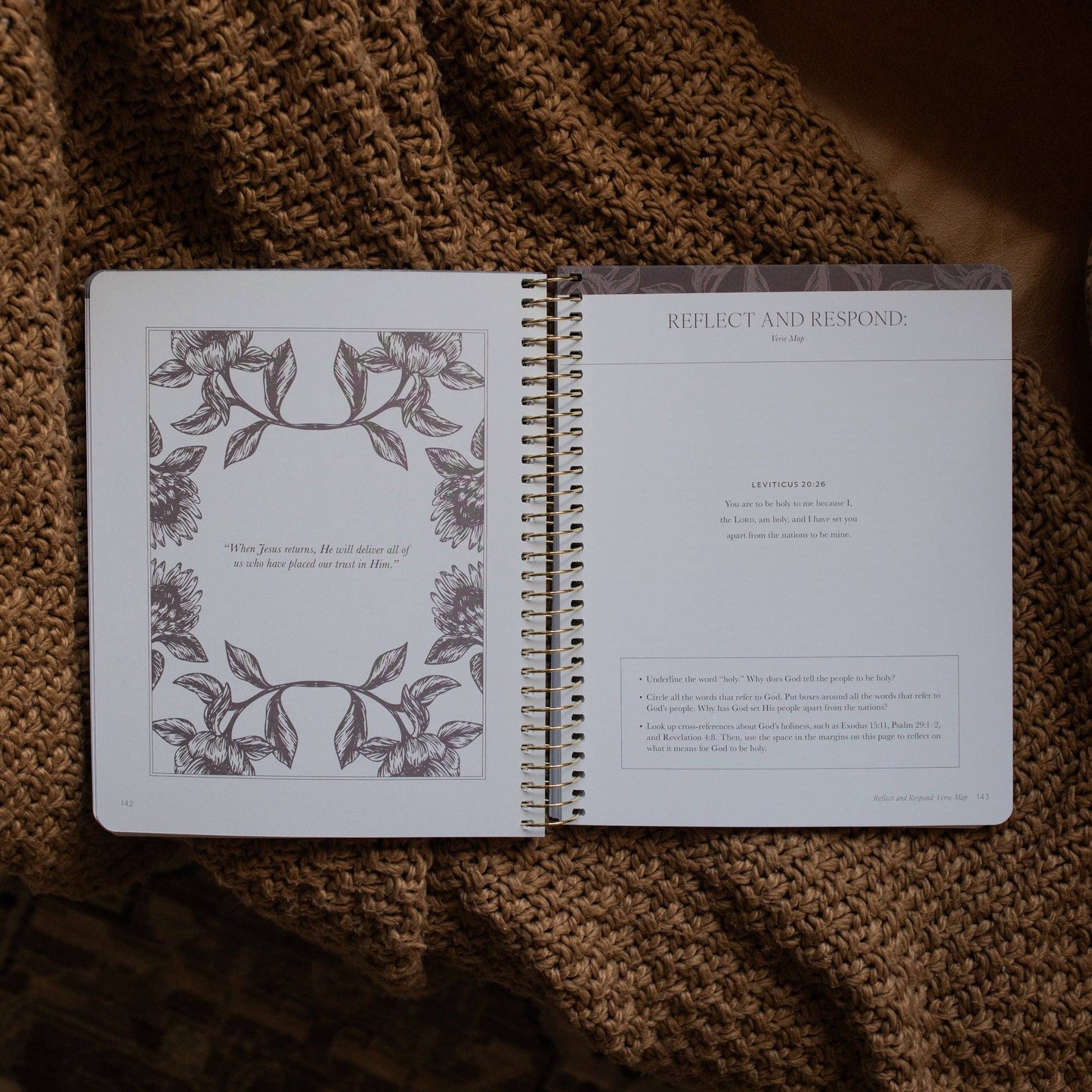 Open spiral-bound notebook with floral design on a textured brown surface