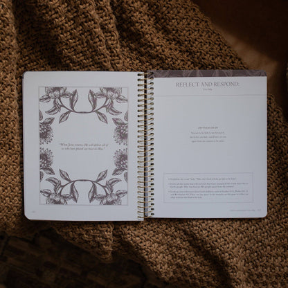 Open spiral-bound notebook with floral design on a textured brown surface